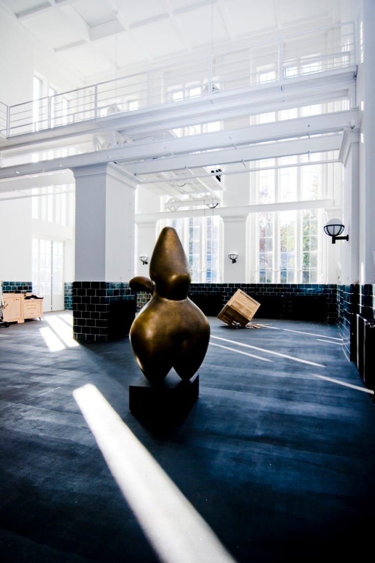 Gallery-like studio space with black floor, white walls and sculptural object in the converted pumping station.