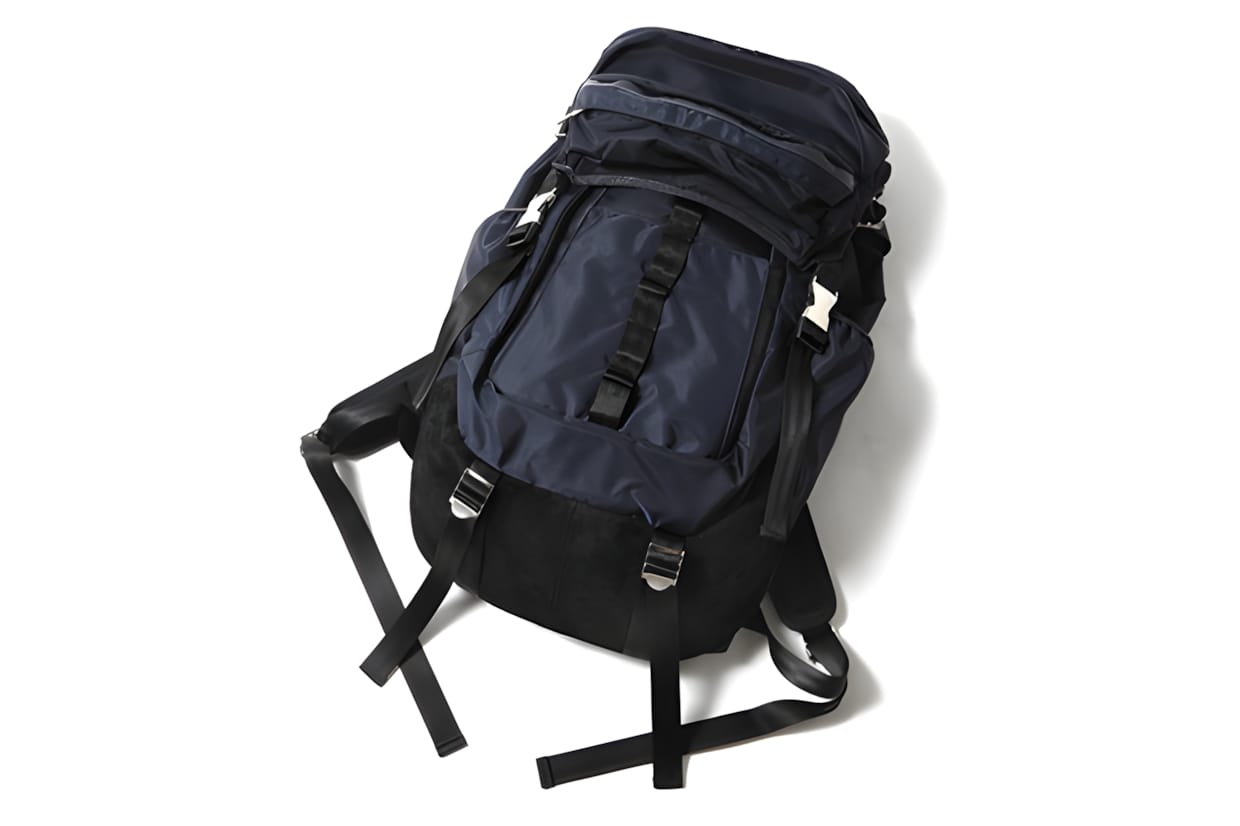 SOPHNET. x visvim Ballistic 23L Backpack in navy — three-quarter rear view showing the shoulder harness and hip belt.