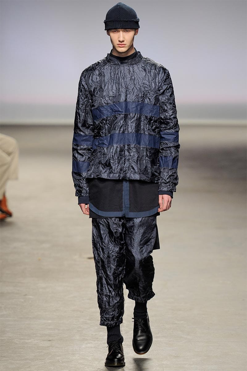 Craig Green FW2013 MAN look 3 — matte white waxed cotton layered top with rolled-hem trousers and wooden plank headwear