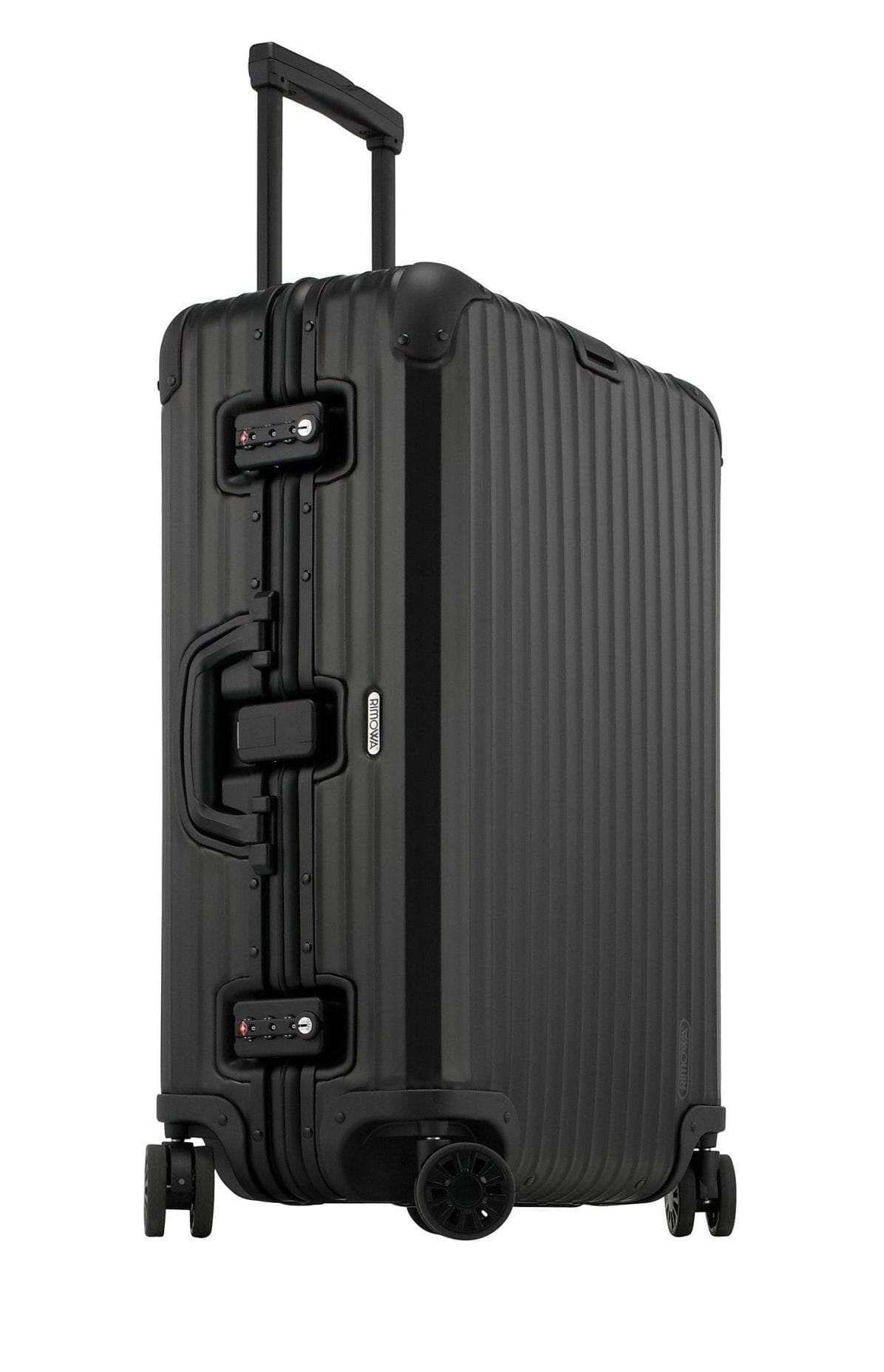 Three-quarter side view of the black Rimowa Topas Stealth with telescoping handle extended, dual TSA combination locks and aluminium frame.