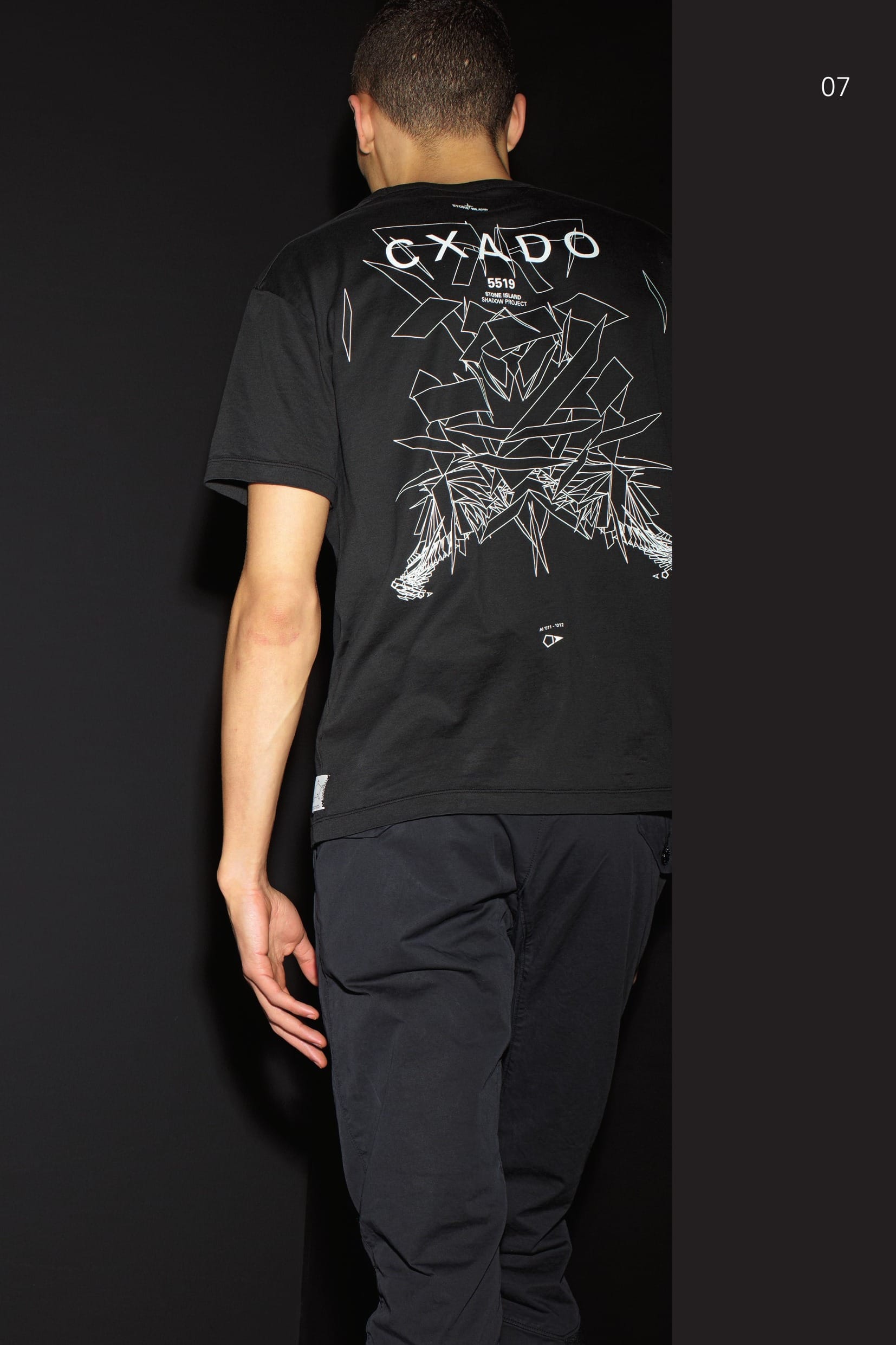 20513 CATEGORY_SKIN_SS PRINTED CATCH POCKET_ JERSEY CO Short-sleeve T-shirt in cotton jersey. Rounded finely ribbed neck. Small CATCH pocket on chest with small vertical opening. Ergonomic seams on the sleeves. Garment dyed. Large CXADO (Shadow in Esperanto) print on the back. 30202 CATEGORY_RESIST_PLEATED PANT_RC1 BATAVIA-T Trousers in performance cotton Batavia. Developed exclusively for STONE ISLAND SHADOW PROJECT this RC1 (Resist Cotton 1-ply) high-density gabardine has been impregnated with Teflon® Fabric Protector during the garment dye process. Haptically cool and precise, the subtle matte-sheen belies the 100% cotton composition of the fabric. _ Single layer construction _ Matte-sheen surface _ Water and stain repellency for ideal wearability _ STONE ISLAND garment dyed Trousers with single dart and diagonal pockets on the front. Two back pockets with flap and button fastening. Shaped knee. Panel in finely ribbed stretch jersey embraces the entire calf. Shaped loops at the waist. Zip and button fly closure.