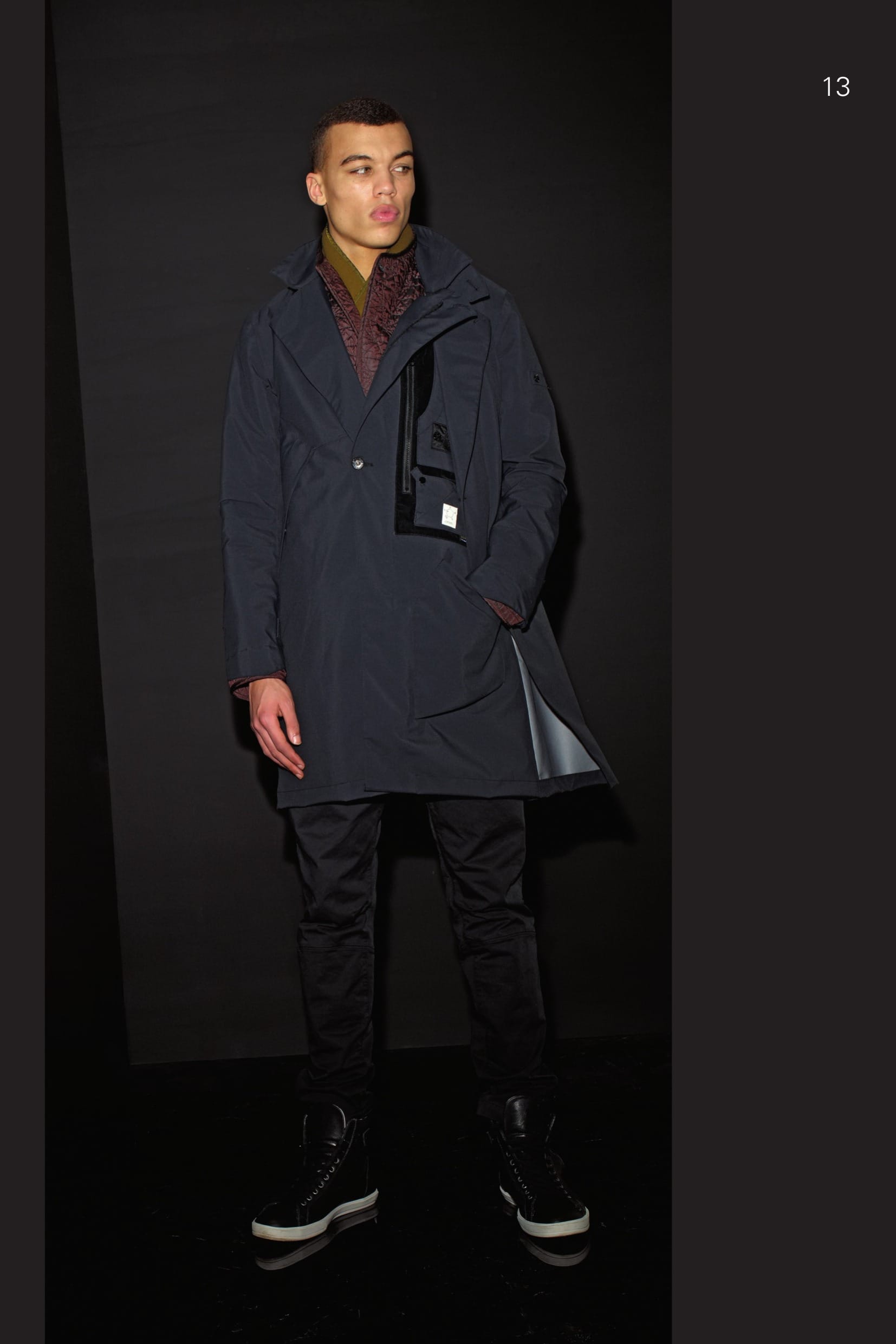 70104 CATEGORY_ PROOF_STEALTH TRENCH COAT_ GORE-TEX® PROSHELL 3L A hero of STONE ISLAND SHADOW ever since the very first season, the shape for the Stealth Coat has evolved to generate a Trench Coat with an innovative design, made in the Gore-Tex® Pro Shell 3L, a triple layered super performance fabric. The culmination of decades of development, Gore-Tex Pro Shell® is the non-plus ultra of protective fabrics. Conceived to endure the harshest of mountain conditions, Pro Shell fabrics are an amazing fusion of the seemingly mutually exclusive properties of toughness and lightness. The revolutionary Gore® Micro Grid Backer takes performance to the next level by reducing weight and bulk, and increasing abrasion resistance. Gore-Seam® Tape and GQS (Gore Quality Standard) performance tests ensure total weather protection. _ Total waterproofness: Gore-Seam® tape and waterproof construction _ Extremely tough, extremely breathable, durably waterproof and windproof _ Engineered for extended and extreme conditions _ Guaranteed to Keep You Dry® The front of the garment is designed with two layers. Outer layer: Two diagonal pockets with hidden snap fastening. Button with double buttonhole to hold the left outer layer to the inner layer. Second inner layer with asymmetrical zip fastening. On the left side is a large chest pocket in flocked nylon with vertical zip fastening and two small bellows pockets and the STONE ISLAND SHADOW badge. Below, a patch pocket applied sideways. Collar with button adjustable chinstrap. Shaped cuffs with adjustable Velcro® bands. Hidden air vent under the sleeves. Inverted pleat on the back. Detachable hood with visor and drawstring. 90311 CATEGORY_EQUIP MODULAR SCARF_BONDED NYLON/PL Scarf in nylon jersey on one side and polyester fur on the other. A new frontier in modular garment accessories. Starting from this collection, accessories have been introduced in the EQUIP category that can be fixed to all the coats and jackets in the PROOF, RESIST and AUGMENT categories for this season, past seasons and the seasons come, designed not only for their primary function, but also to enrich and add a further dimension the overall look. The accessories can be fixed to the garments using the loops at the neck. Garment dyed. 40406 CATEGORY_AUGMENT MODULAR QUILTED LINER_ IRIDESCENT NYLON/PL Light jacket in quilted and padded iridescent nylon/ polyester blend. Garments in the AUGMENT category can be fixed to those in the PROOF and RESIST categories using the loops at the neck and buttons at the cuffs, in order to increase the system thermo properties. Raised collar. Slightly rounded bottom hem. Hidden snap fastening. Garment dyed. 30202 CATEGORY_RESIST_PLEATED PANT_RC1 BATAVIA-T Trousers in performance cotton Batavia. Developed exclusively for STONE ISLAND SHADOW PROJECT this RC1 (Resist Cotton 1-ply) high-density gabardine has been impregnated with Teflon® Fabric Protector during the garment dye process. Haptically cool and precise, the subtle matte-sheen belies the 100% cotton composition of the fabric. _ Single layer construction _ Matte-sheen surface _ Water and stain repellency for ideal wearability _ STONE ISLAND garment dyed Trousers with single dart and diagonal pockets on the front. Two back pockets with flap and button fastening. Shaped knee. Panel in finely ribbed stretch jersey embraces the entire calf. Shaped loops at the waist. Zip and button fly closure.