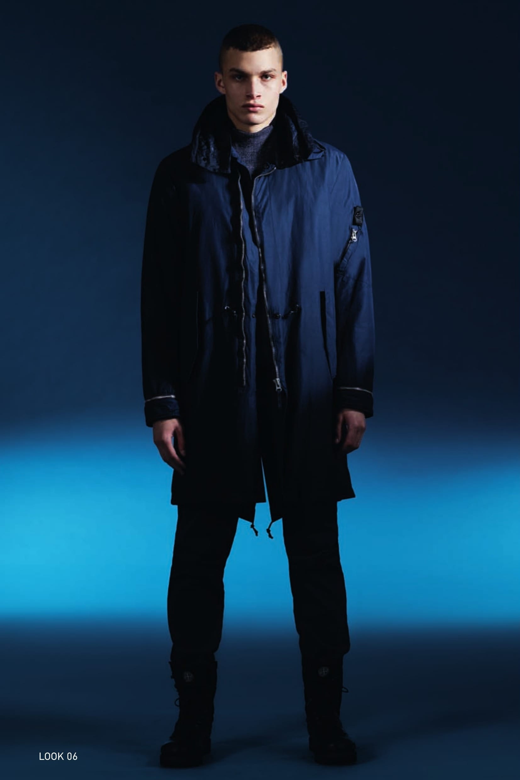 70504 FISHTAIL PARKA_NYCO CANVAS WITH THERMAL INSULATION Fishtail parka in NYCO, nylon/cotton canvas resin-treated on the inside for water and wind resistance. Garment dyed with double dyeing recipe. Large detachable hood with inner edging and wind flap on the neck, double-layered in cotton nylon canvas, lightly padded and quilted with a star pattern. Two diagonal pockets with flap and hidden snap fastening. Zip-fastening pocket on one sleeve: the pocket partially covers the Stone Island Shadow Project badge. Air vent under the armhole. Cuffs rimmed by an adjustable metal zip concealing a ribbed jersey fingerless glove. Drawstring at waist. Fishtail drawstring in back bottom hem. The garment may be shortened using the inner snap fasteners. The inside is lined with a technical nylon mesh, quilted with a star pattern with a fine polyester padding substrate, which guarantees the heat insulation of the garment. Metal zip fastening slightly off-centre, mounted on cotton tape. 502A1 TURTLE NECK_WO/PL/PA JACQUARD State of the Art in knitwear construction. Mock turtle neck knit in a blend of wool, polyester and polyamide yarns seamlessly woven with a combination of jacquard and placed intarsia techniques. 30610 CHINO_CO DIAGONAL Chinos in diagonal weave comfort cotton. Garment dyed. Two diagonal side pockets. Two back pockets with flap and partially concealed button fastening. Reinforced crotch. Zip fly and semi-concealed button at the waist.