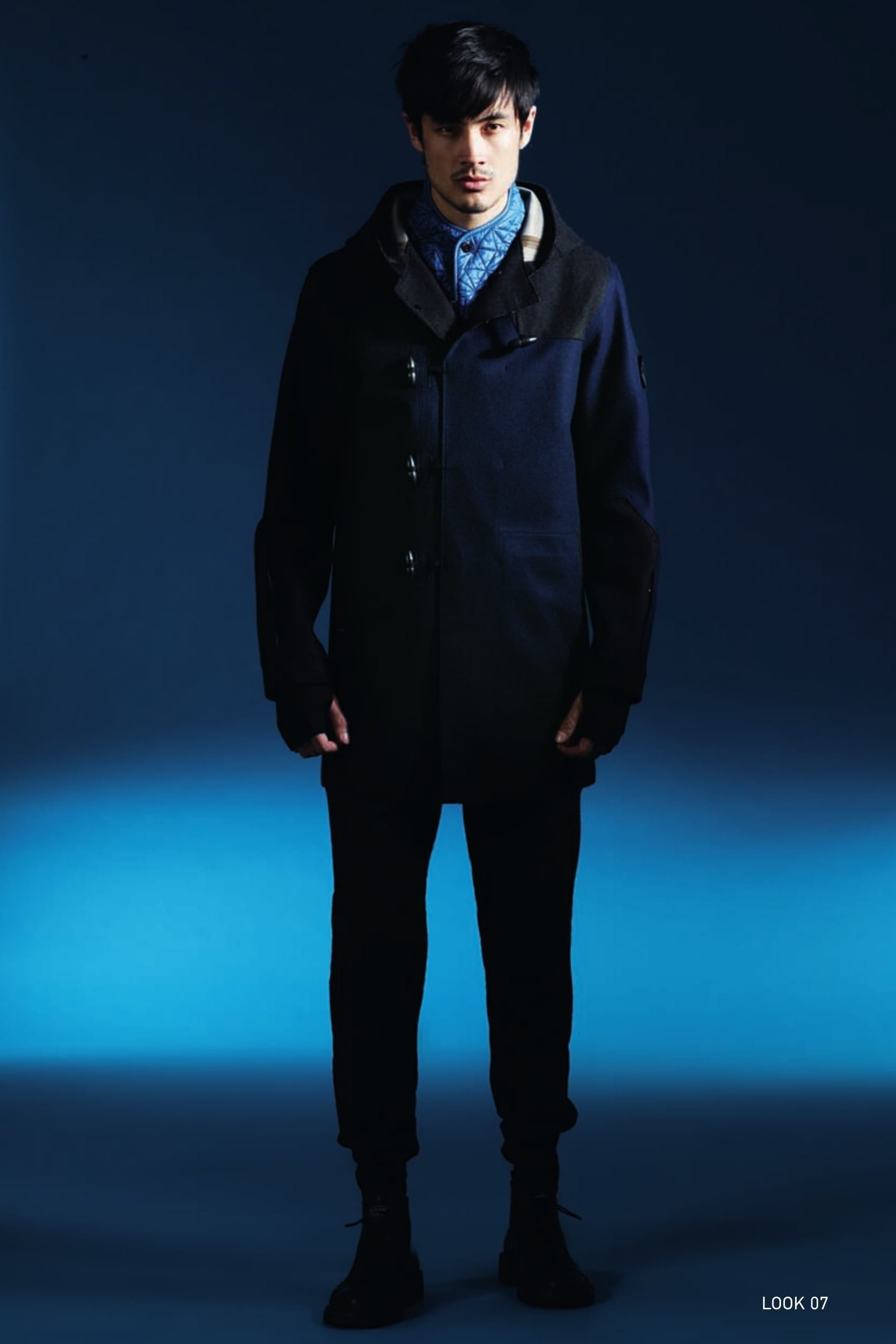 70303 DUFFEL COAT_PW3 TECH WOOL Duffel coat in PW3 Tech Wool. Developed exclusively for Stone Island Shadow Project, PW3 is a weatherproof wool fabric with 3 composite layers. Designed to combine elegance and protection, it represents the ideal fusion of tradition and technology. The natural wool face is laminated to a breathable, water and wind resistant membrane, protected by an inner synthetic mesh. The unlined construction and fully heat-sealed triple-layered fabric makes the garments extremely contemporary both for their aesthetic value and their range of use. Raw cut edge construction. Shaped hood with horizontal drawstring concealed by a flap. Front and back shaped yoke. Inlay pocket construction with horizontal opening and hidden metal zip fastening. Ergonomic sleeve construction. On the left sleeve, the Stone Island Shadow Project badge is partly concealed by a flap. Pocket with vertical opening hidden by a flap at the cuffs. Back split. Loop and toggle fastening on raw cut edge openings on the body of the garment, reinforced with tape. G0308 MODULAR AUGMENT INSULATION VEST_IRIDESCENT NYLON QUILTED Vest in a lightweight iridescent nylon quilted with a star-pattern to a padding substrate. Garment dyed. Tapes and snap fasteners at the neck allow the vest to be integrated in all Stone Island Shadow Project shoulder pieces, both from this season and past and future seasons. Shaped raised collar. Vertical side pockets. Rounded bottom hem. Metal zip fastening slightly off-centre. 30505 NARROW PLEATED PANT _WOOL/LINEN/NYLON Trousers with single dart in brushed wool/ linen/nylon twill fabric. Specific double garment dyeing recipes allow superb colour and multi-tone depth to this triple composition fabric. Diagonal side pockets. Two back pockets with flap and button fastening. Stretch jersey insert on bottom hem of leg. Zip fly and button at the waist.