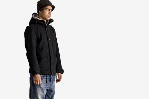Model in a charcoal Stussy Japan Fall 2011 wool hooded mountain jacket and knit cap.