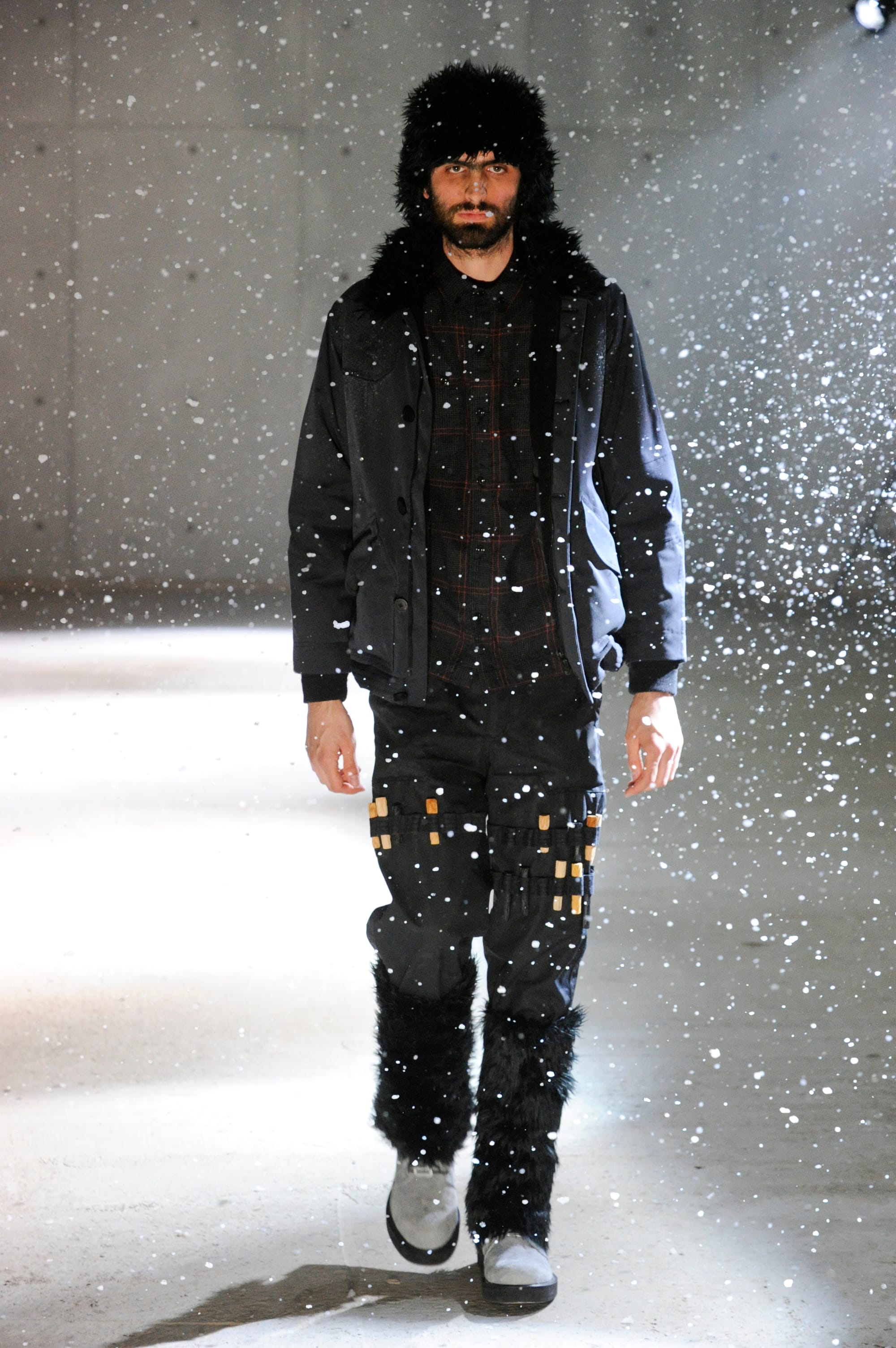 White Mountaineering Wilderness Outfitters look 4: black field jacket, fur hat, plaid shirt and utility trousers.