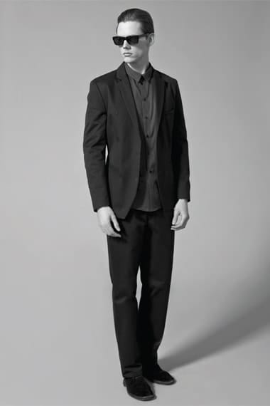 Johannes Niermann in black Stahl Corporation tailoring and sunglasses.