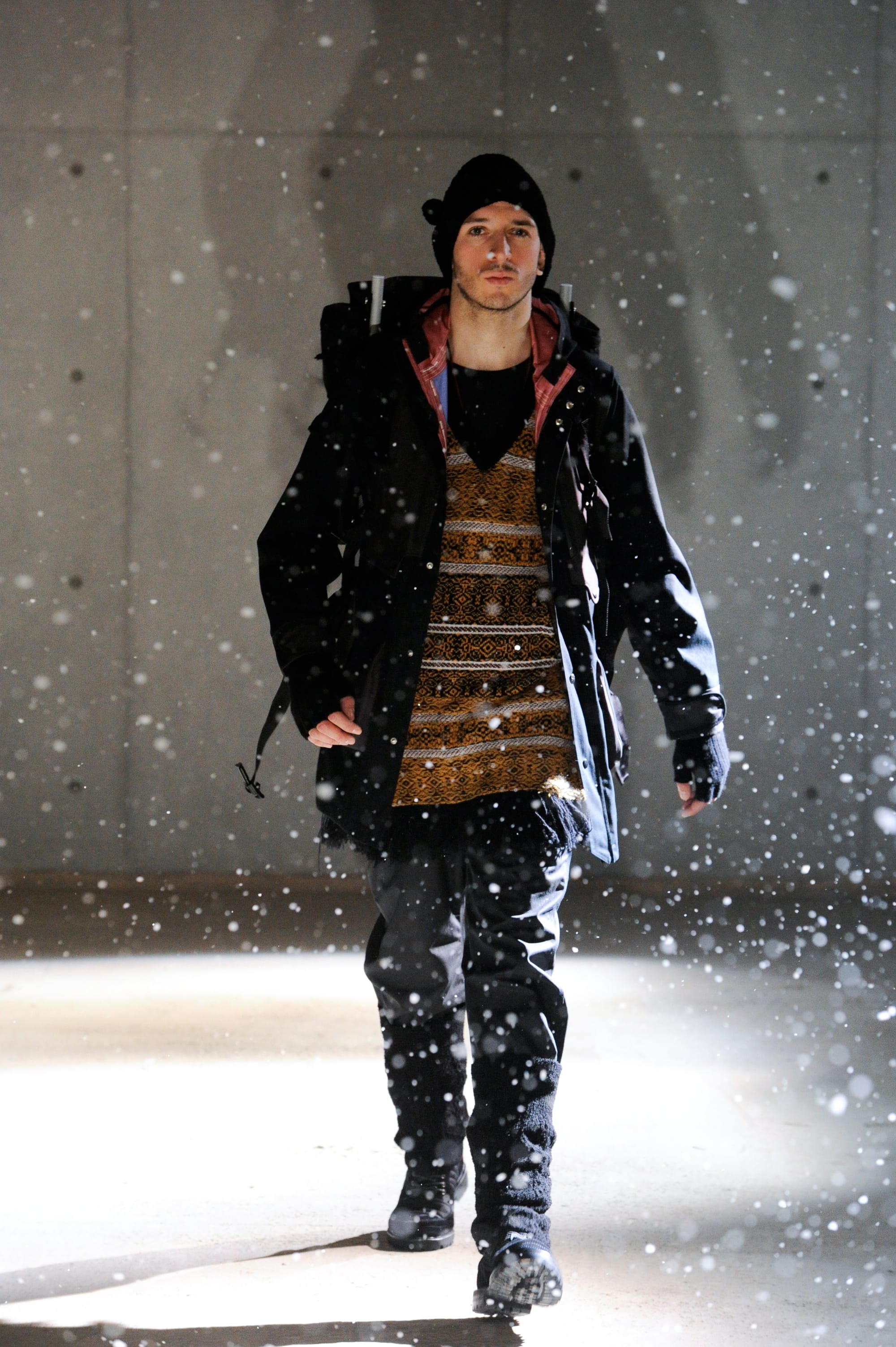 White Mountaineering Wilderness Outfitters look 6: backpack harness, dark plaid outer layer and black utility trousers.