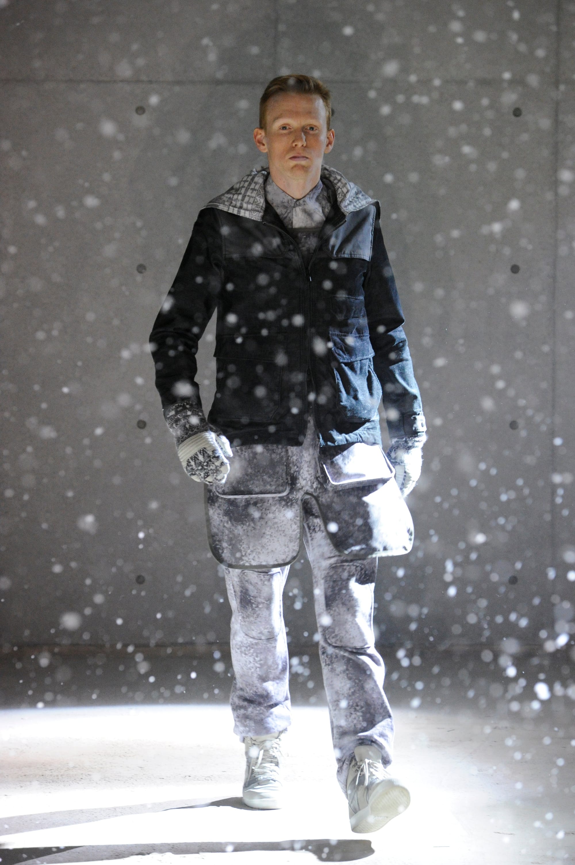 White Mountaineering Wilderness Outfitters look 8: grey camouflage hooded suit with backpack and tactical belt.