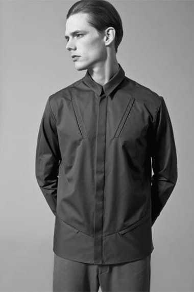 Johannes Niermann in a dark concealed-placket shirt with angular chest panels.