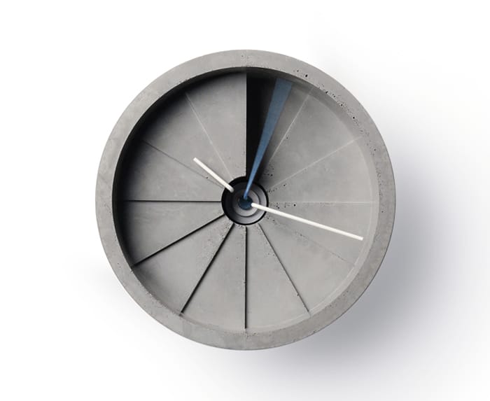 Top-front view of the 4th Dimension concrete clock showing its twelve radial steps and blue second hand.