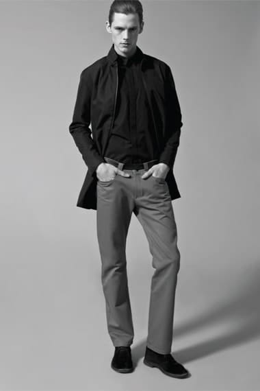 Johannes Niermann in a black shirt jacket and grey cropped trousers from Stahl Corporation.