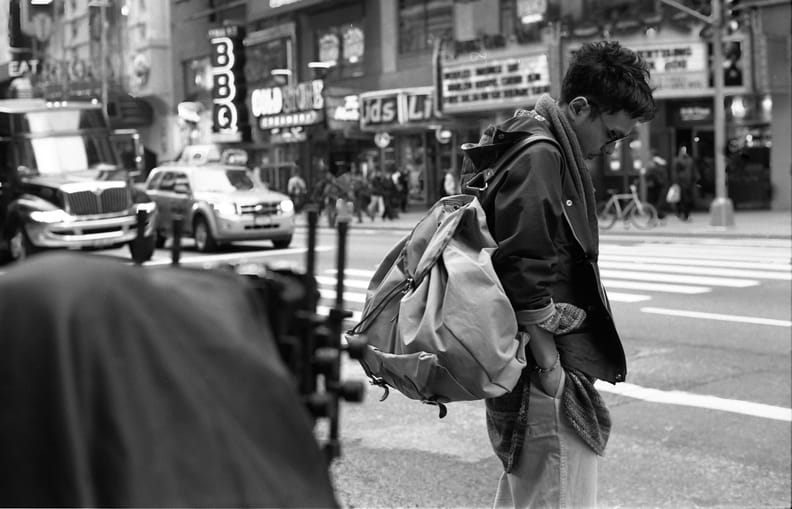 Model carrying an oversized bag on a Times Square crosswalk during the Times Square Redux shoot.