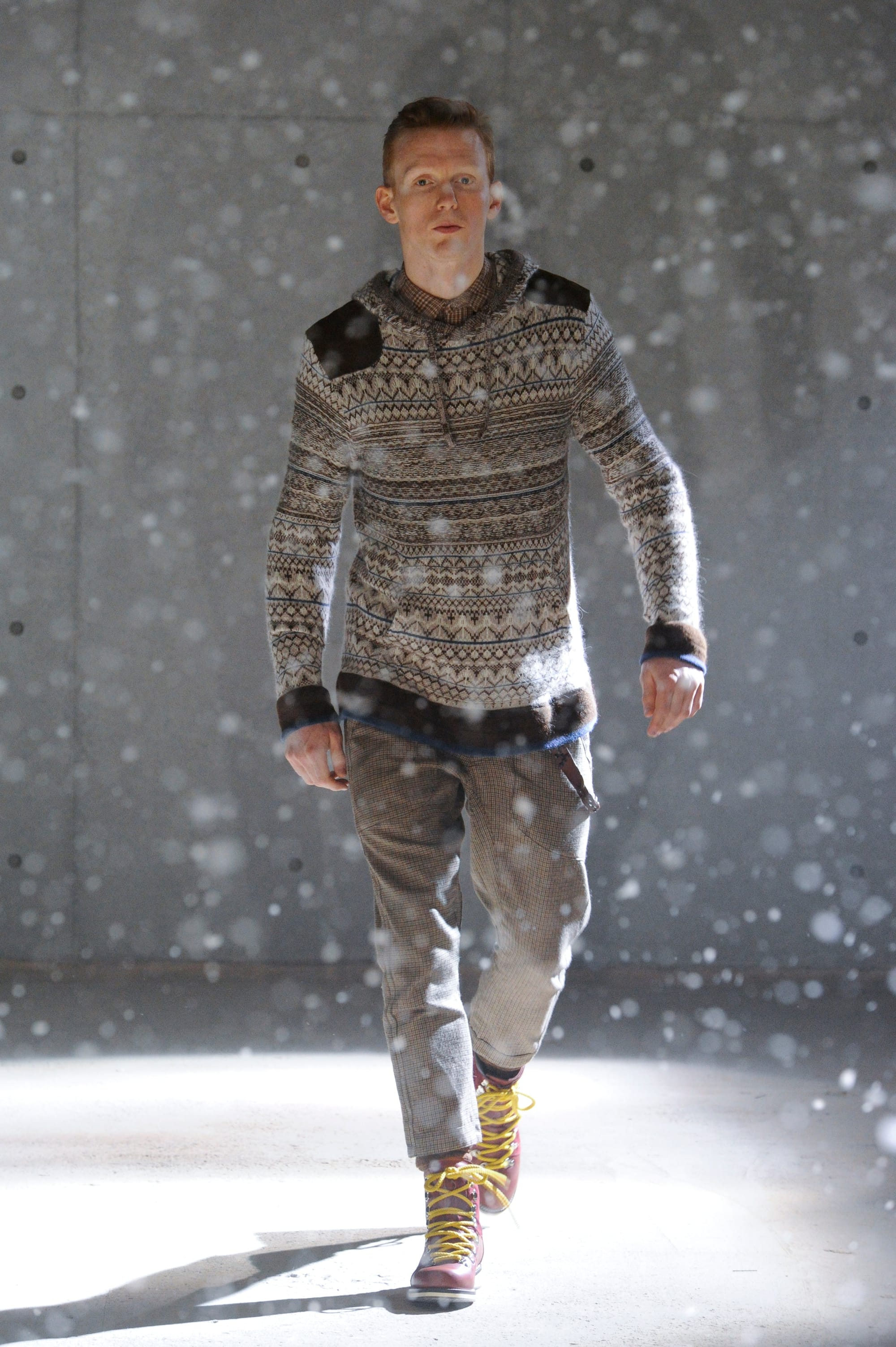 White Mountaineering Wilderness Outfitters look 13: brown patterned blanket cape over black layers.