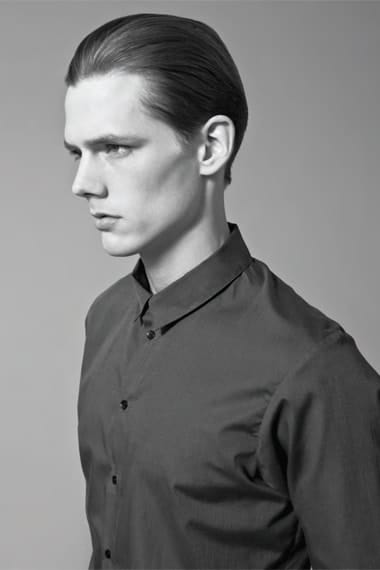 Close profile portrait in a dark narrow-collar Stahl Corporation shirt.