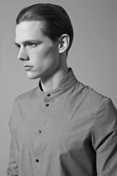 Close portrait in an asymmetric grey stand-collar Stahl Corporation shirt.
