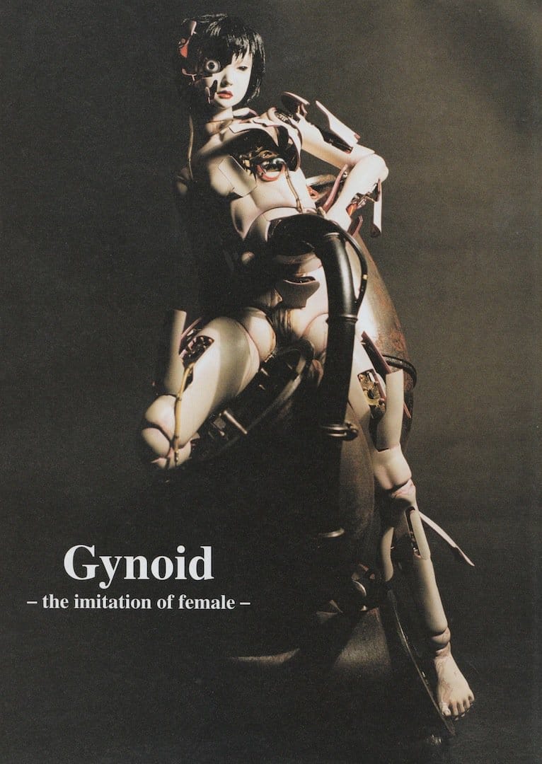 Full-length Gynoid model from Innocence posed against a dark background with Gynoid — the imitation of female — text.