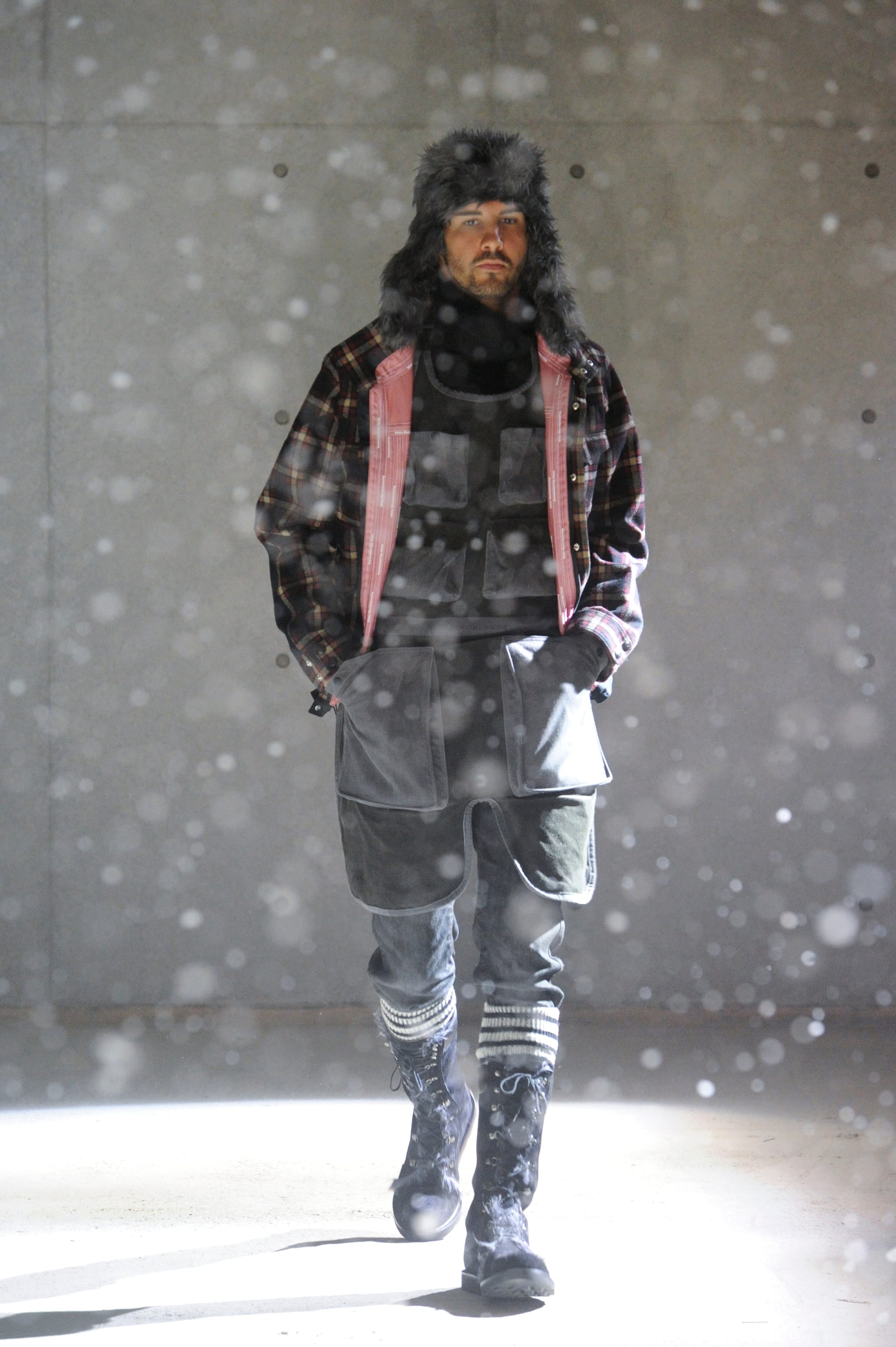 White Mountaineering Wilderness Outfitters look 23: black and grey patchwork coat with asymmetric trousers.