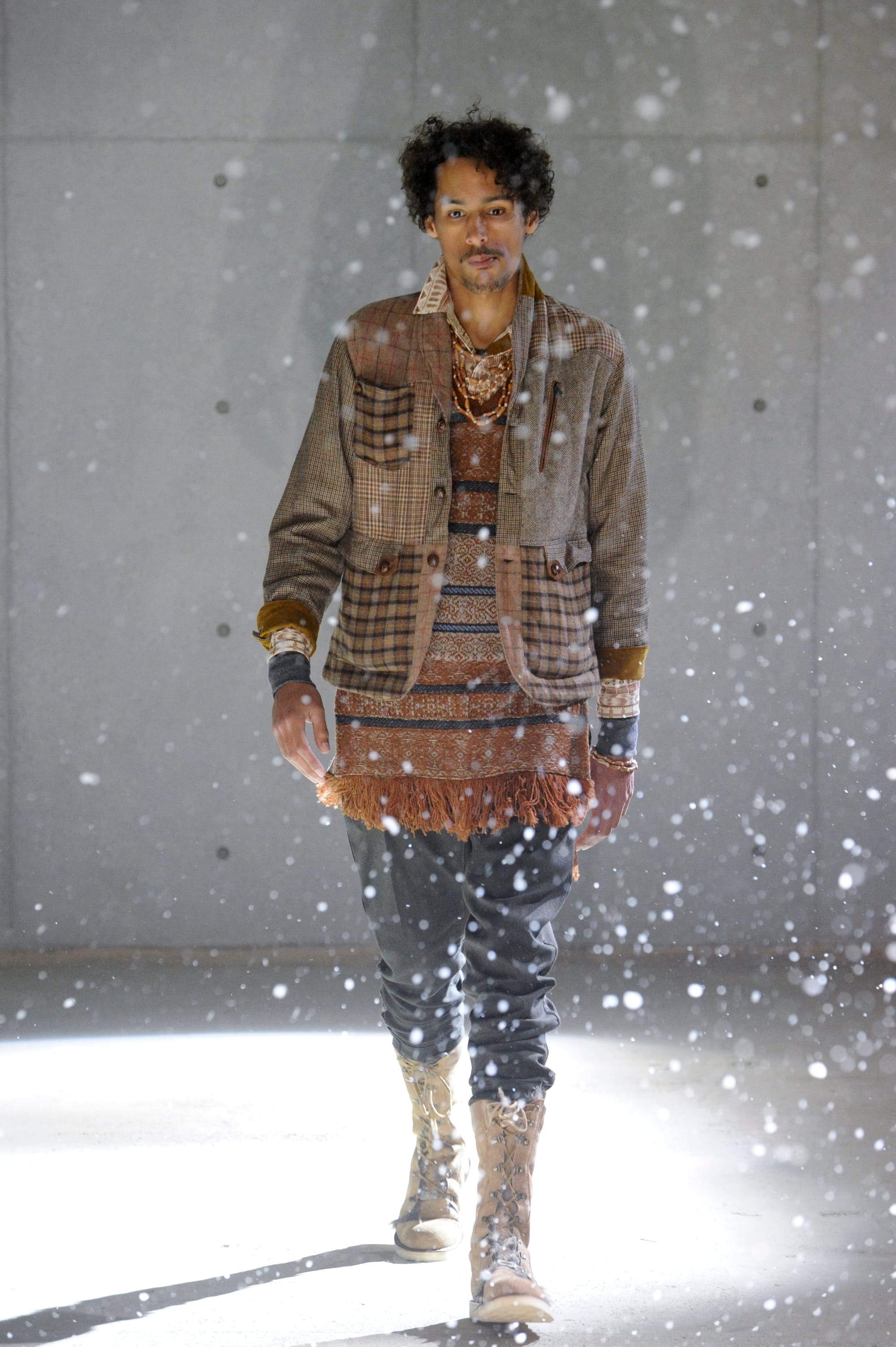 White Mountaineering Wilderness Outfitters look 25: grey technical field jacket over plaid and cargo trousers.