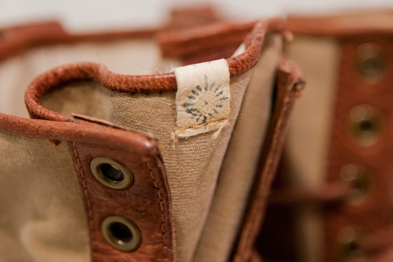 Close view of the visvim fabric label and tan canvas ankle panel on the Grizzly Boots Mid-Folk.