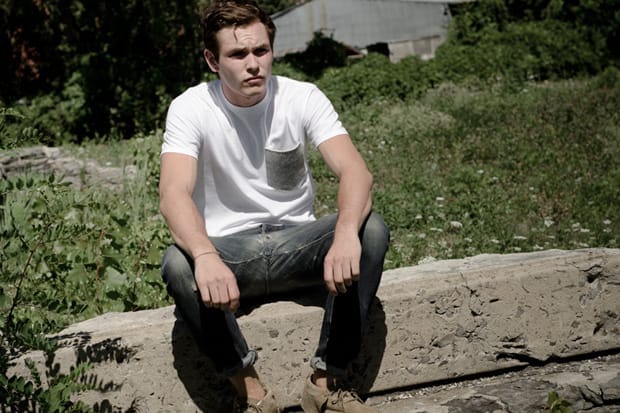 Model wearing a white pocket T-shirt and cuffed dark jeans for Deadwood Fall/Winter 2012.