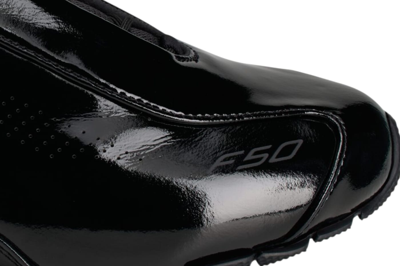 Close-up of the F50 mark and glossy black patent leather toe