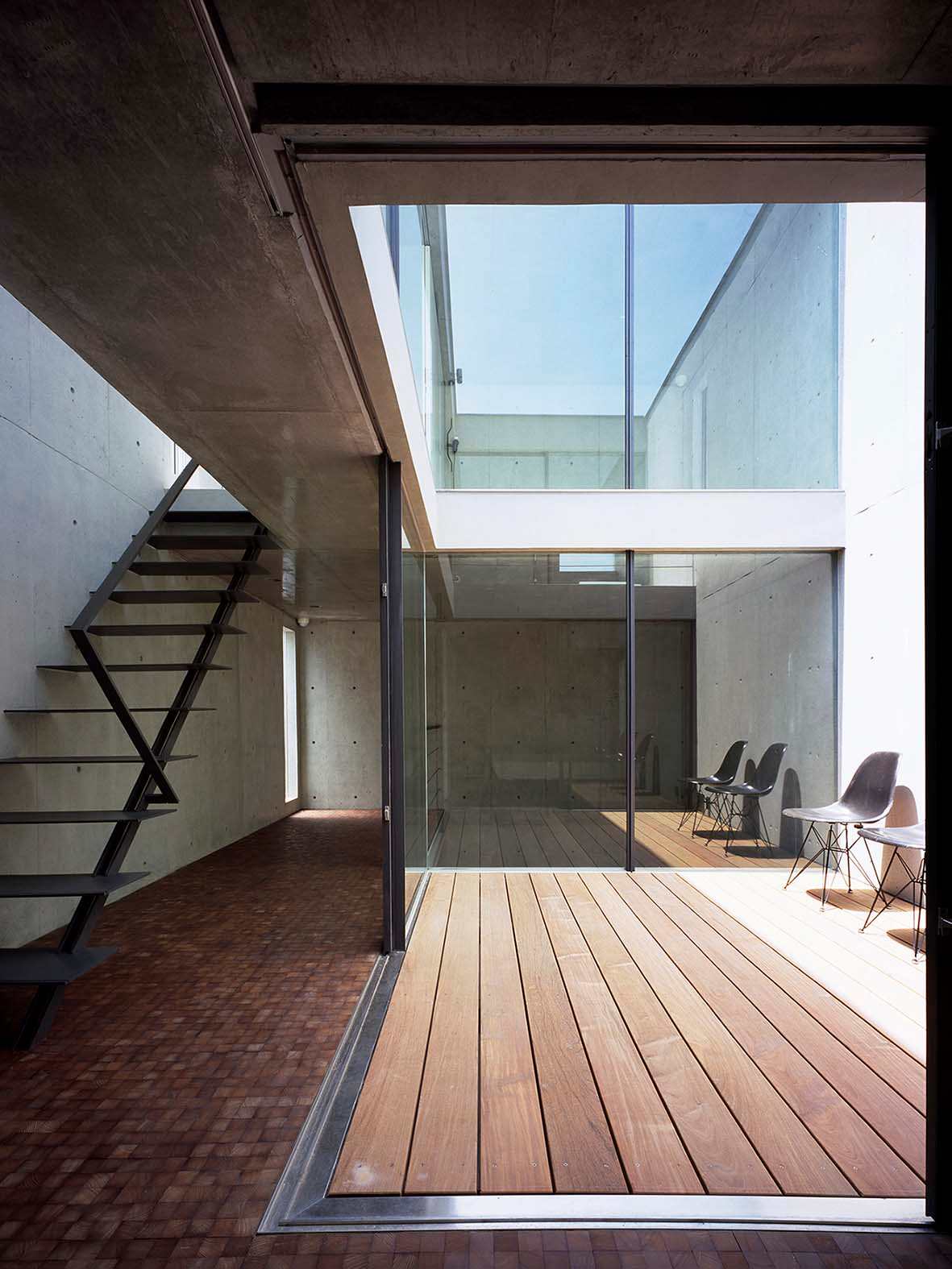 Vertical courtyard, steel stair and glass walls inside 2COURTS HOUSE in Tokyo.