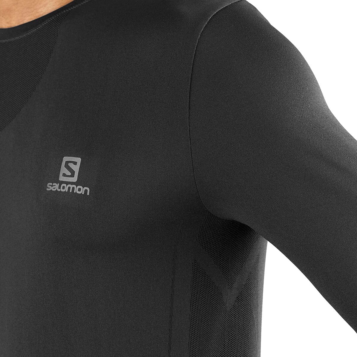 Worn close-up of the black Salomon Sense Pro men's long-sleeve top, showing reflective chest branding and body-mapped mesh ventilation beneath the arm. Retail item code SAL01RO and model...