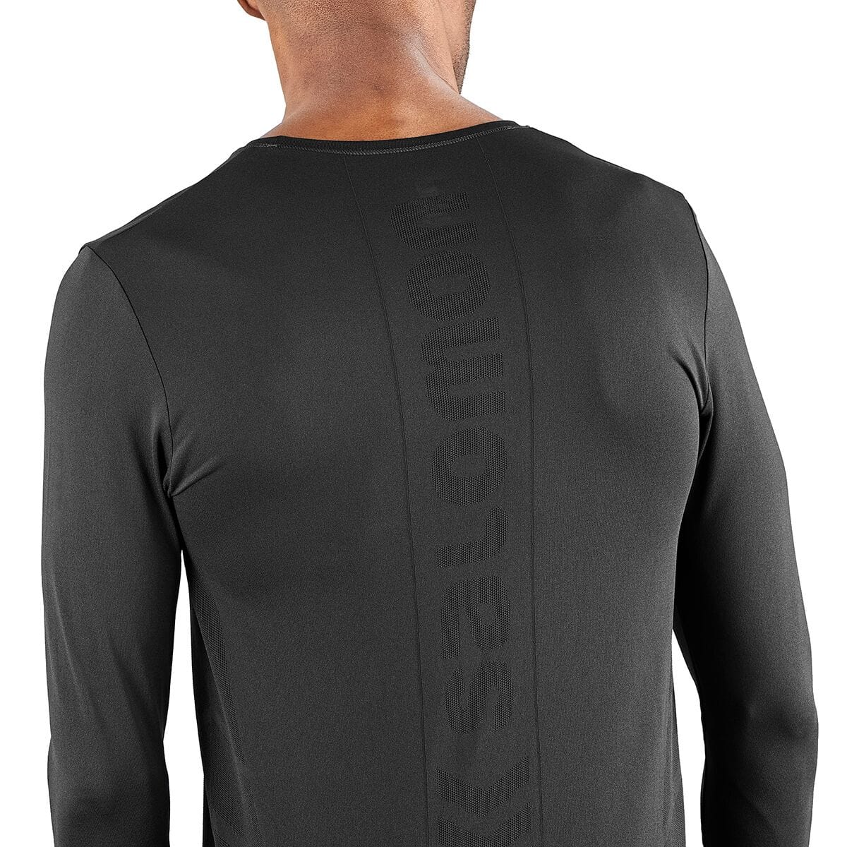 Worn rear close-up of the black Salomon Sense Pro men's long-sleeve top, showing vertical tonal SALOMON lettering and chevron body-mapped knit ventilation. Retail item code SAL01RO and mo...