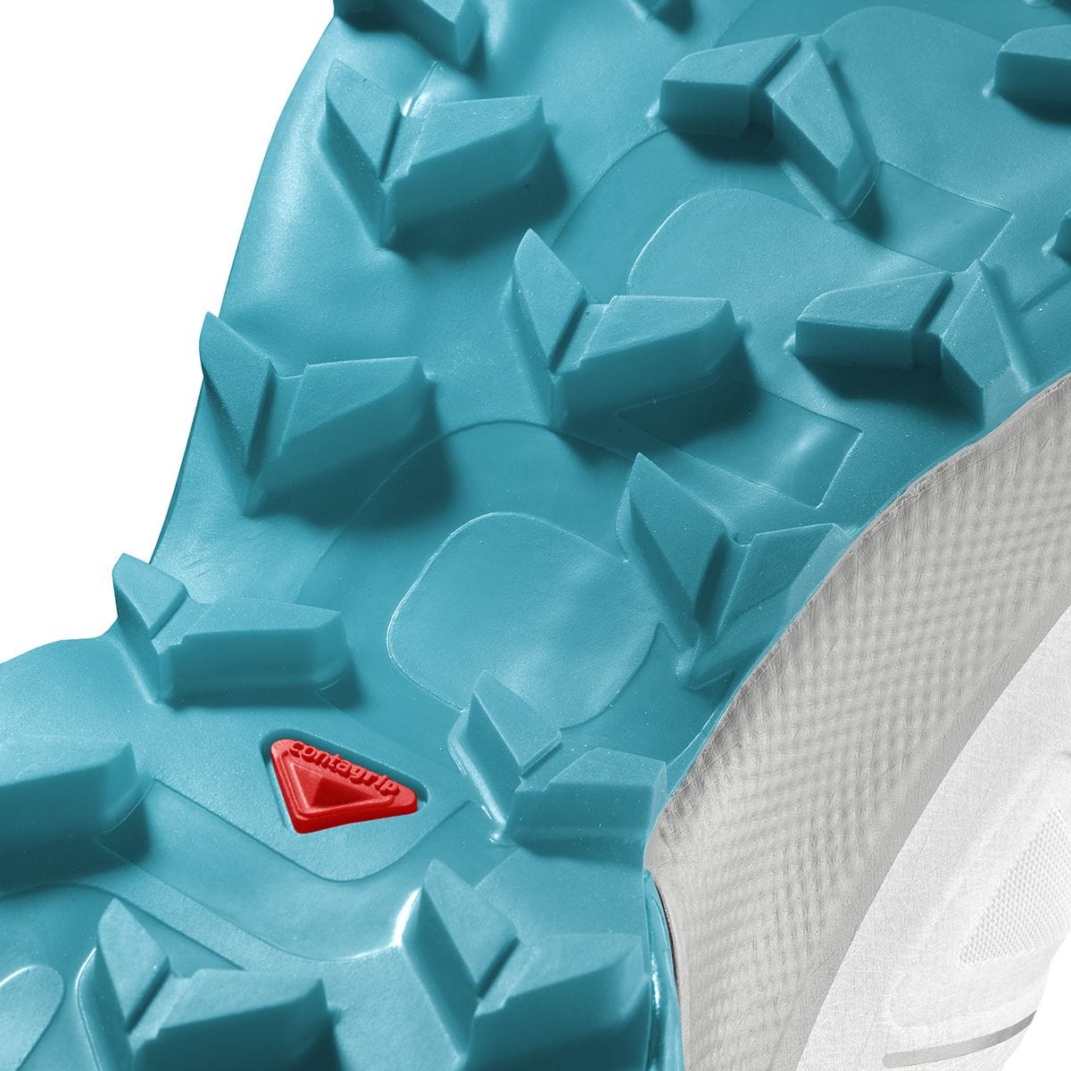 Macro view of the turquoise Salomon Speedcross 5 outsole, highlighting the directional Mud Contagrip lugs, red Contagrip badge, and textured white sidewall. Retail item code SAL01PA is so...