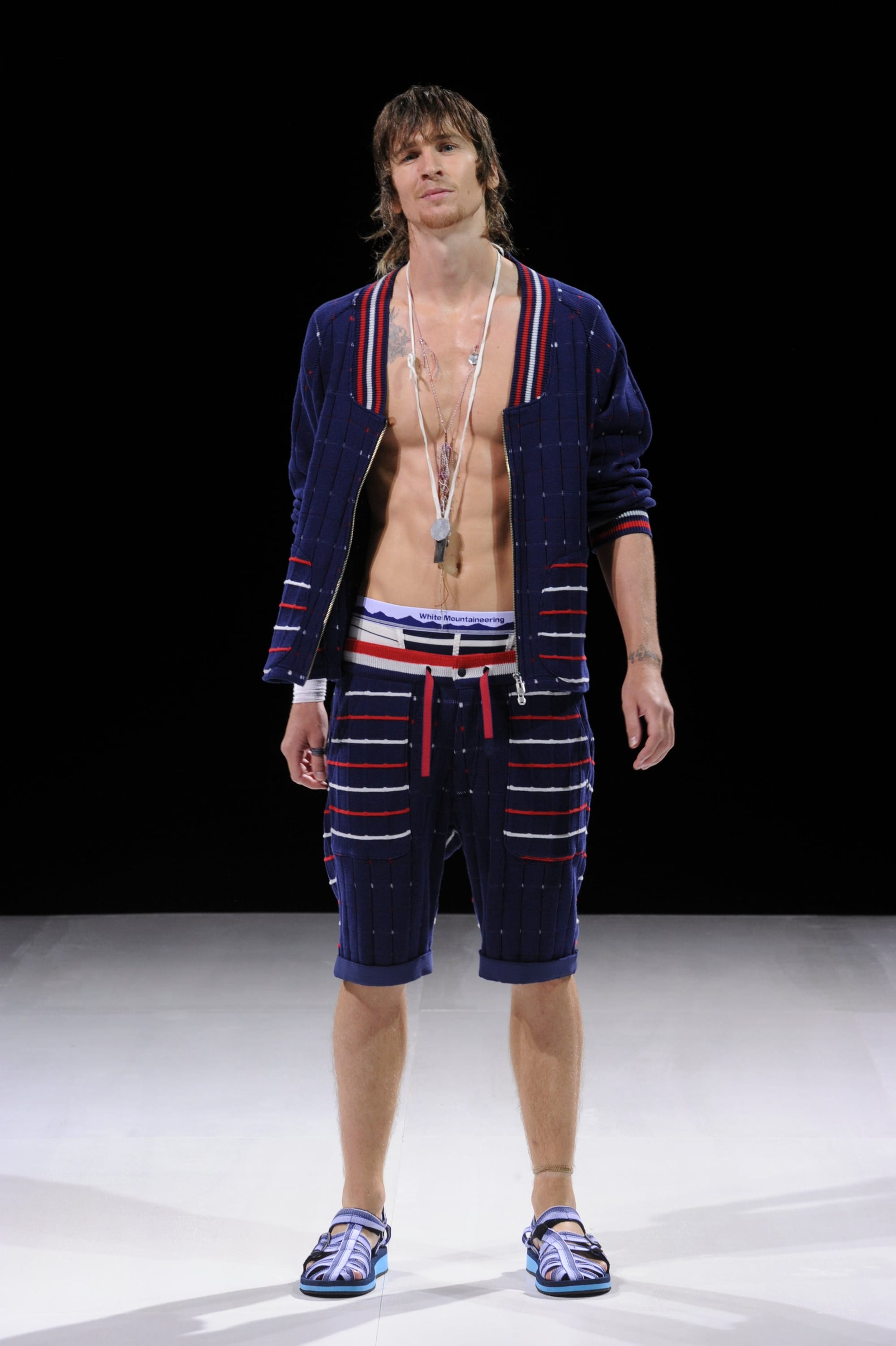 Model in an open navy striped cardigan with matching shorts and striped sandals.