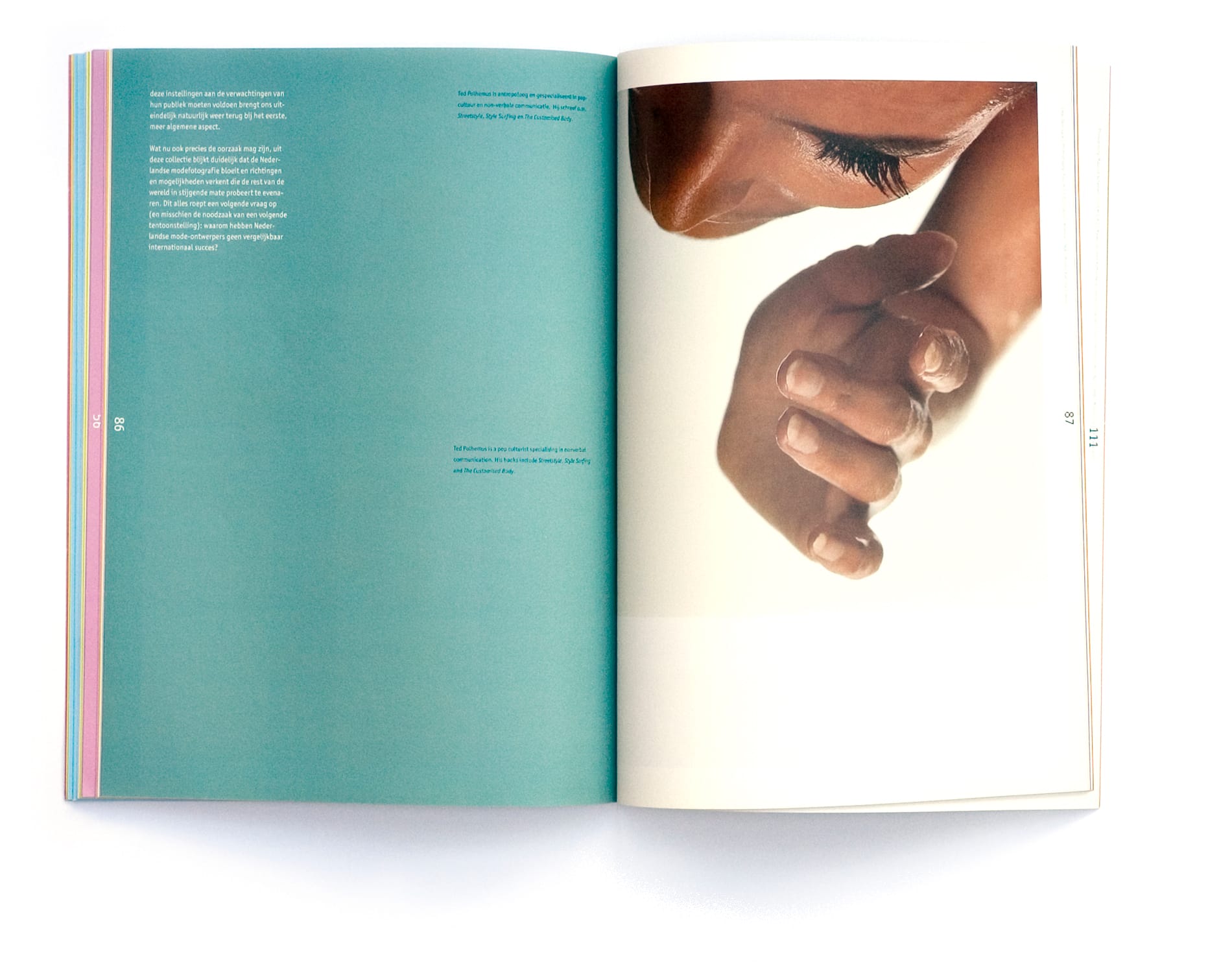 Teal essay spread with a close-up eye above curled fingers or toes against white.