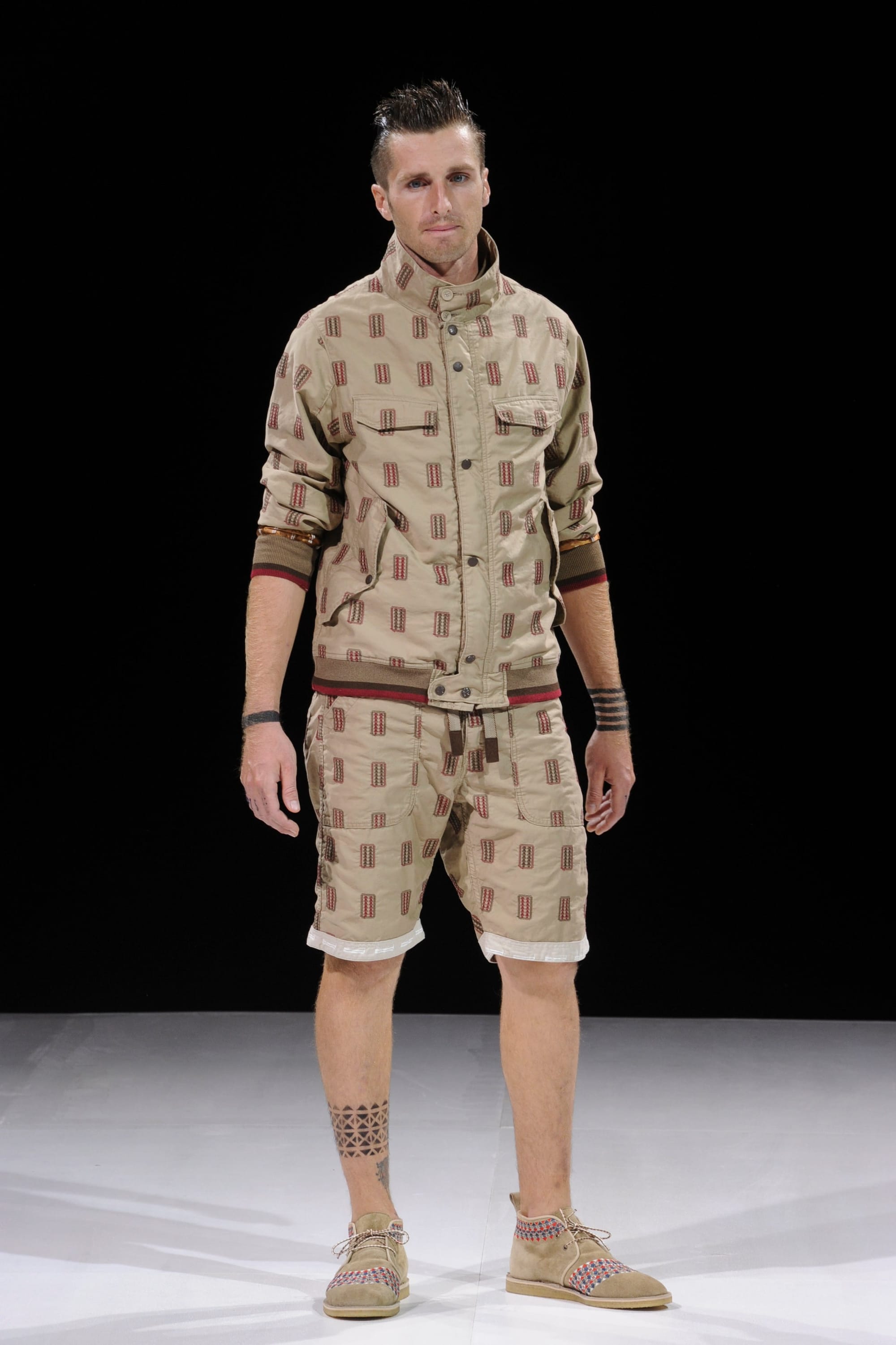Model in a beige geometric-print jacket and matching shorts.