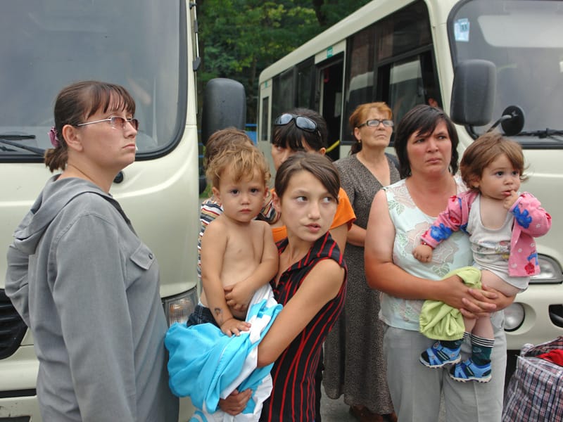 South Ossetian refugees, including women and children, beside buses while fleeing to North Ossetia.