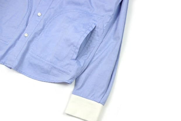 UNTOLD powder-blue button-up shirt detail with an angled side pocket and contrasting white cuff.
