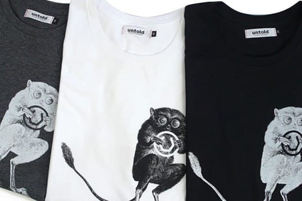 UNTOLD grey, white and black T-shirts with owl graphics incorporating the circular U logo.