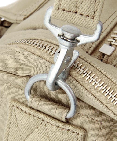 Beige shoulder-strap clip and metal ring detail.