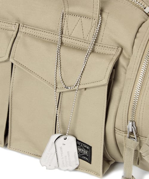 Beige front pocket, PORTER label and dog tags on the PEACE BOSTON BAG MEDIUM.