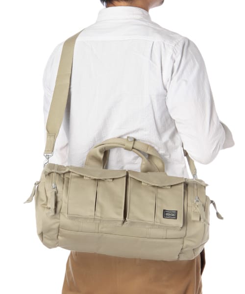 Rear view of the beige PORTER PEACE BOSTON BAG MEDIUM worn with its shoulder strap.