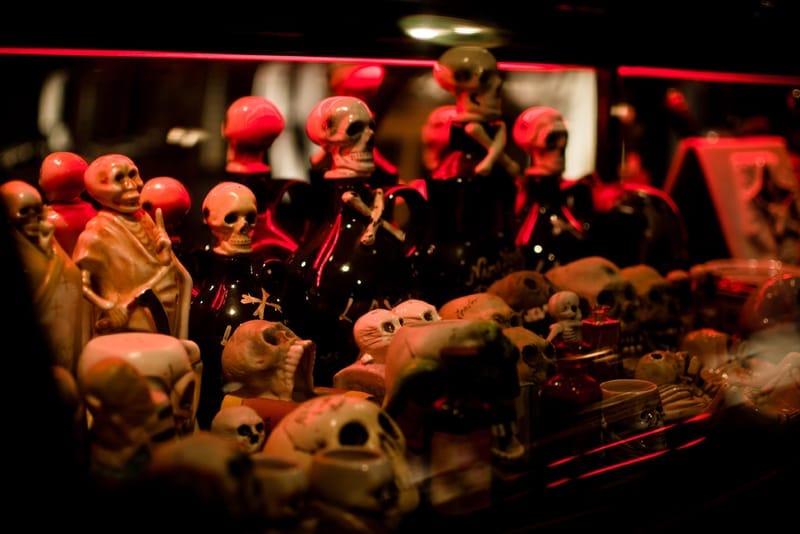 Skull and skeleton figurines in a red-lit display case at NEIGHBORHOOD Shibuya.
