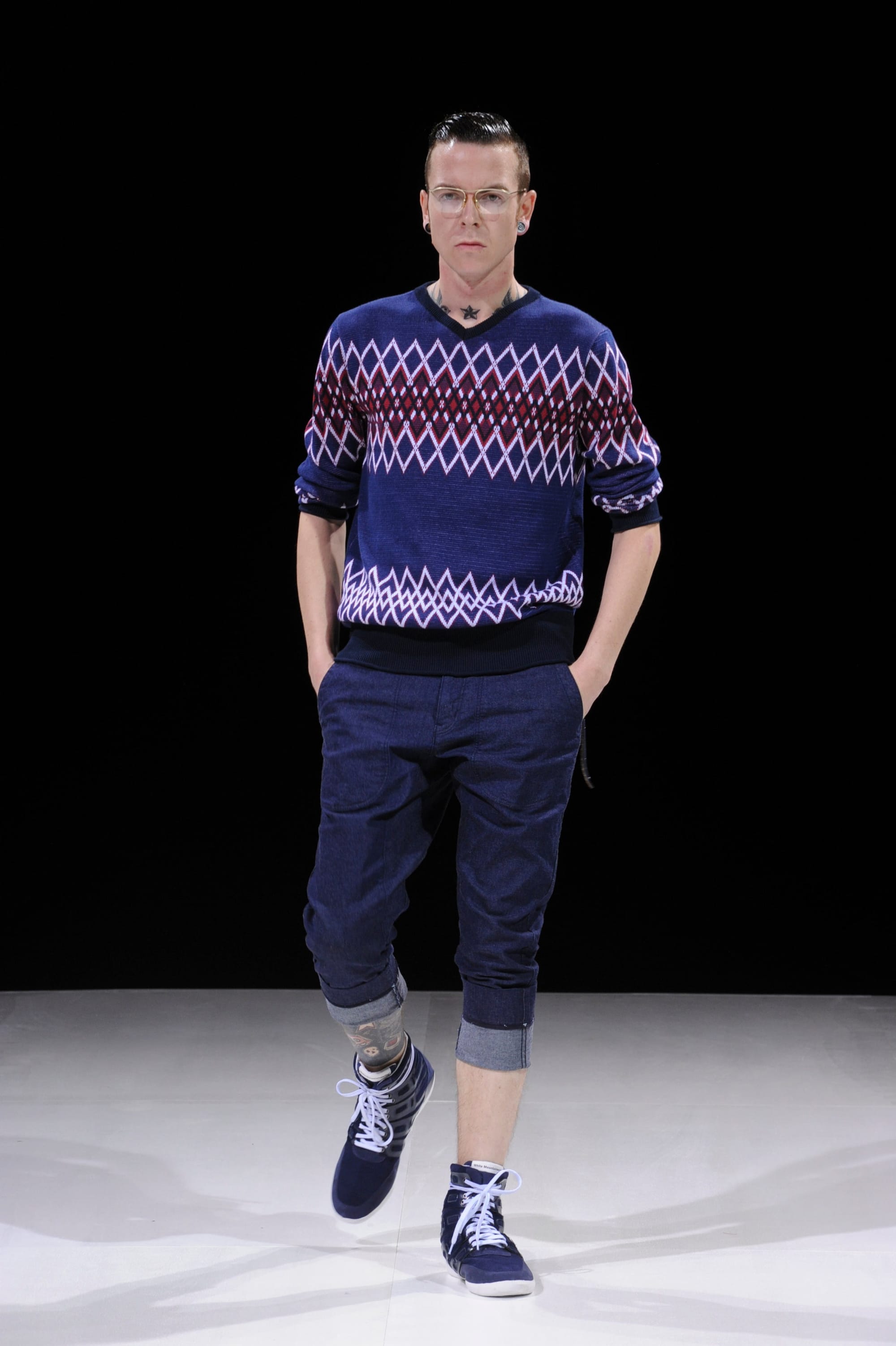 Model in a navy geometric knit top and rolled navy trousers.
