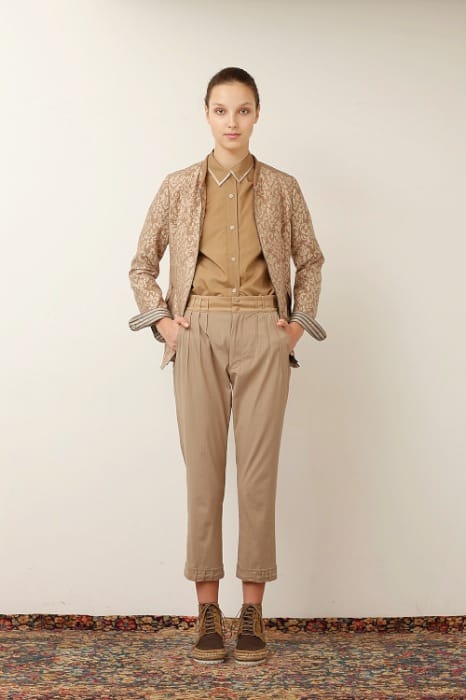 White Mountaineering womenswear model in a tan patterned cardigan, tan shirt and beige cropped trousers.