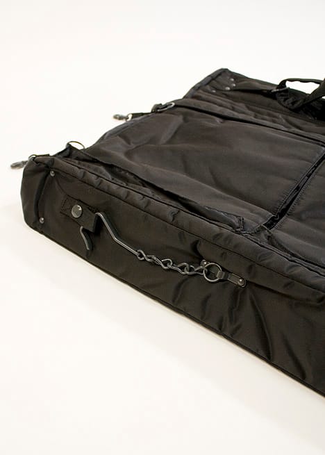 Close view of the Porter Tanker garment bag's hanging hook, snap tab and edge hardware.