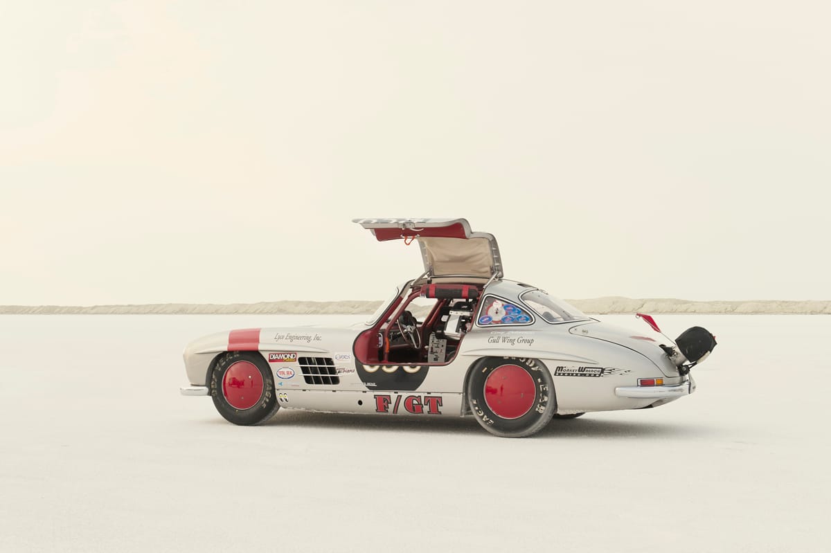 Silver gullwing land-speed race car with its door open on the Bonneville Salt Flats during SpeedWeek 2012.