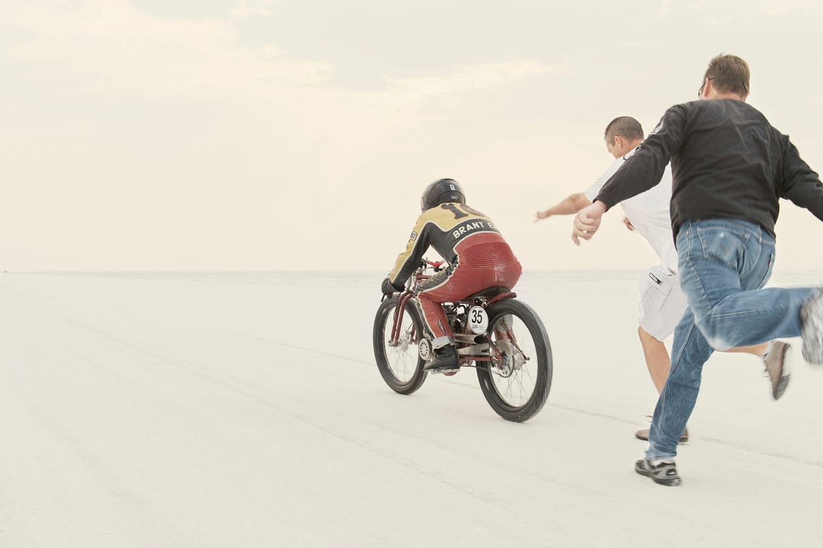 Crew members pushing bike 35 as its rider leaves the starting line at Bonneville SpeedWeek 2012.