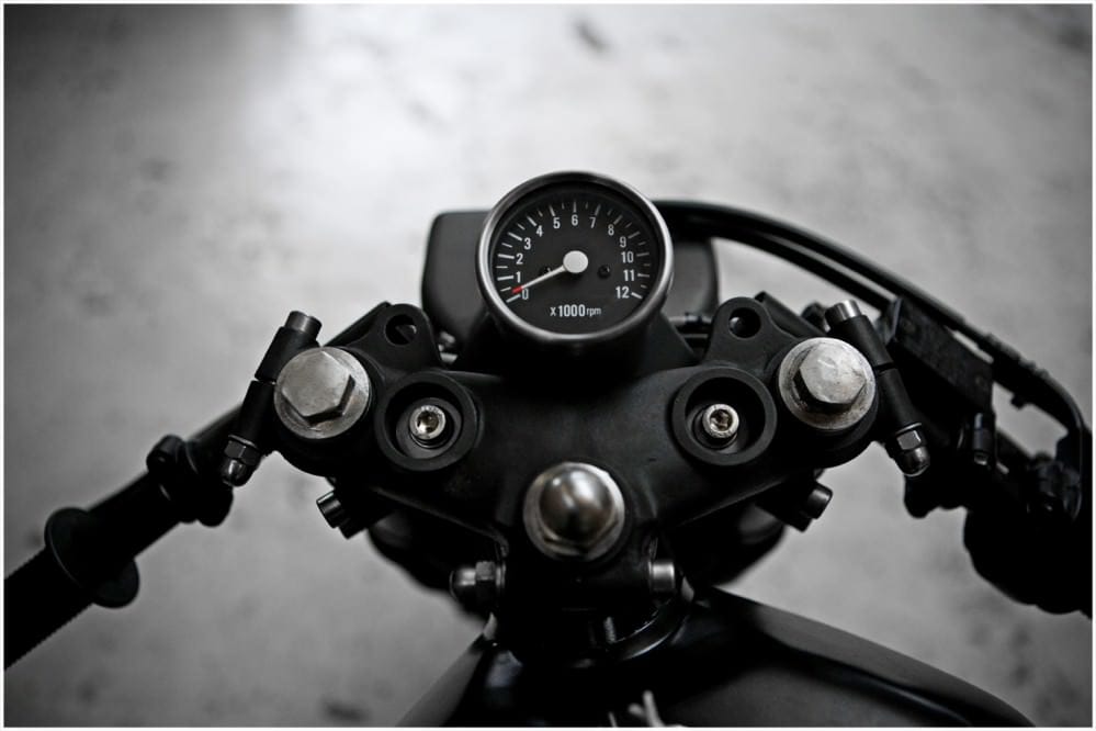 Close view of the Yamaha RD400's central tachometer, clip-on handlebars and top yoke.