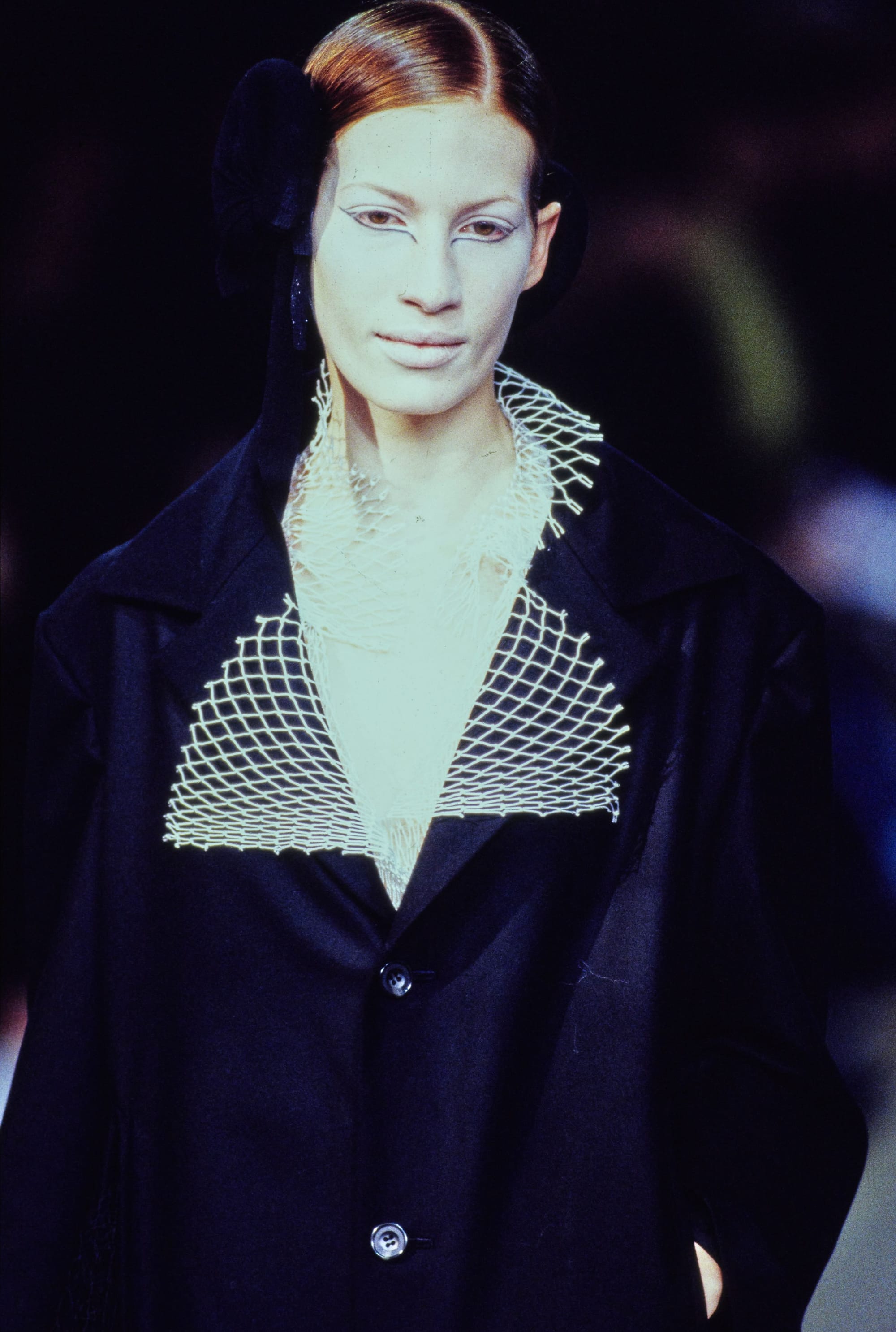 Yohji Yamamoto Fall 1995 detail 19: Close view of a dark coat with a wide white lattice-like collar.