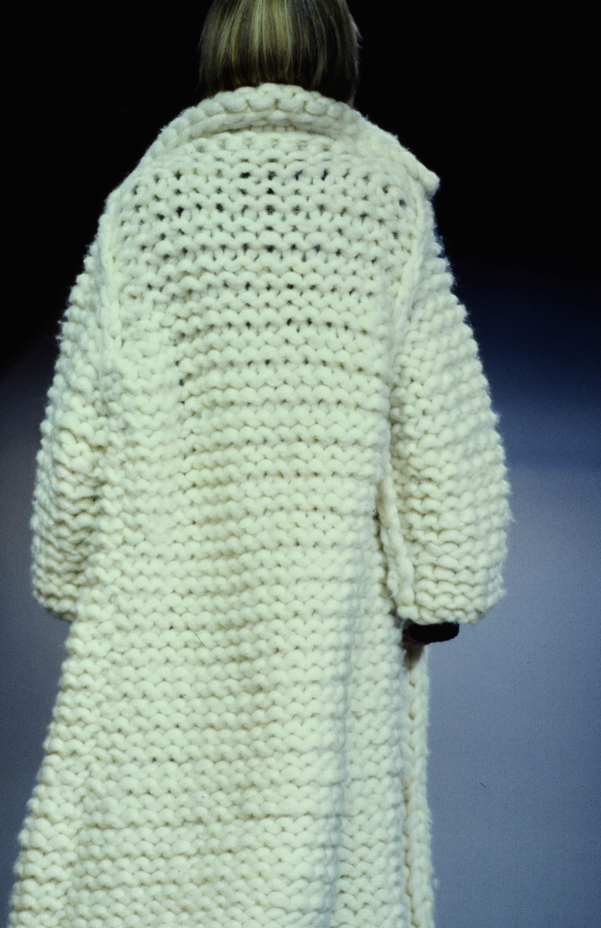 Yohji Yamamoto Fall 1995 detail 36: Rear view of a white coat made from oversized chunky knit stitches.
