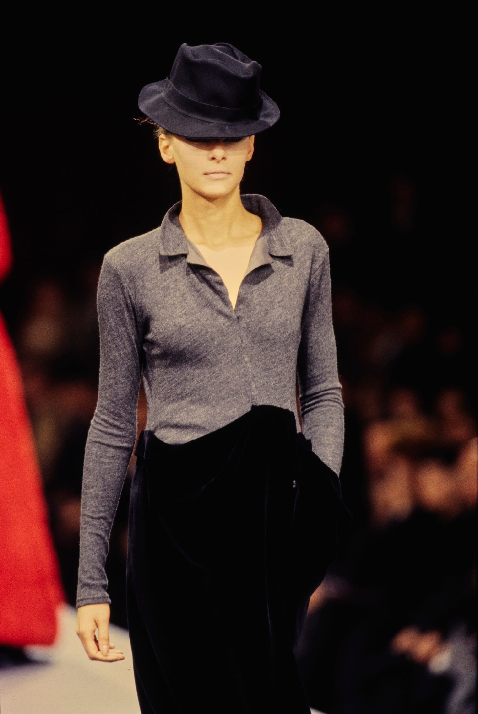 Yohji Yamamoto Fall 1995 detail 44: Grey collared fitted top above a high-waisted gathered black skirt and a black hat.