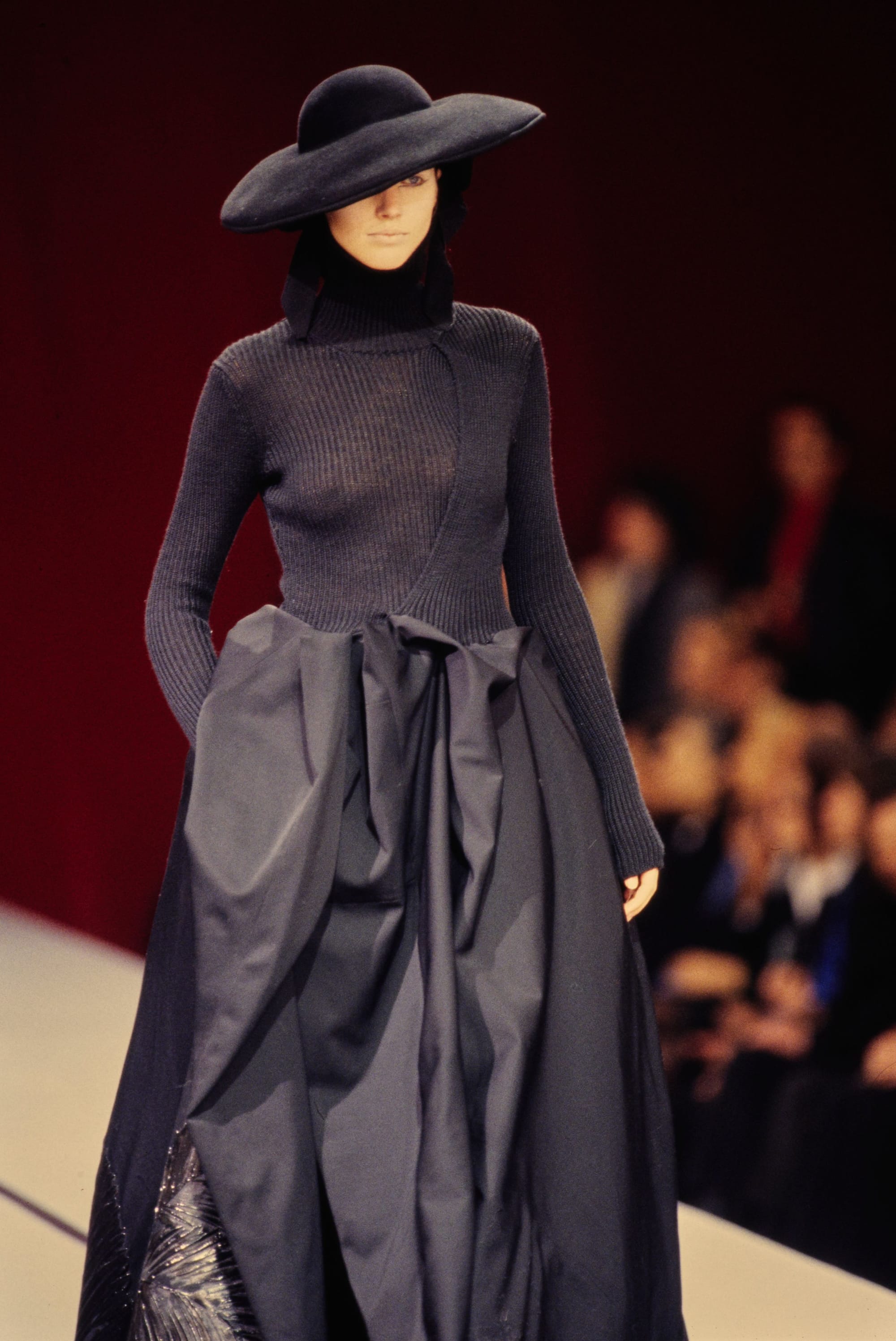 Yohji Yamamoto Fall 1995 detail 68: Wide black hat, ribbed dark turtleneck and voluminous grey gathered skirt.